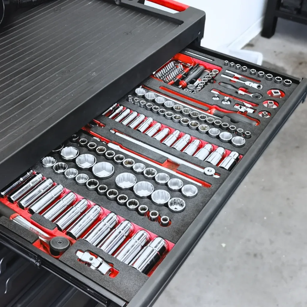 Servante d'atelier bien organisée et remplie d'outils (douilles et cliquets) chez ValueMyCar