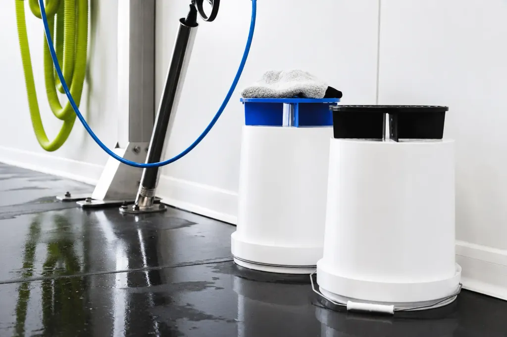 Seaux de lavage et lance haute pression au sol du box